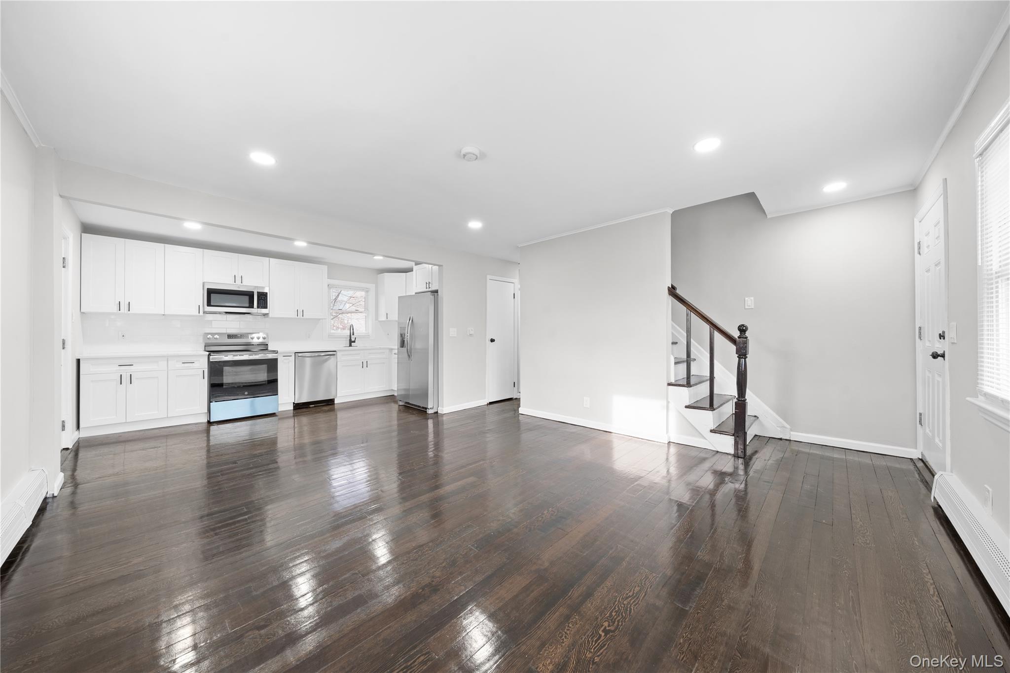 193 North Arizona Road West Babylon, NY 11704 - Photo 8 of 37 a view of an empty room with wooden floor and a kitchen