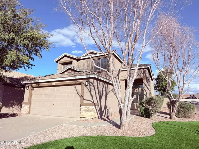a view of a white house with a yard and plants