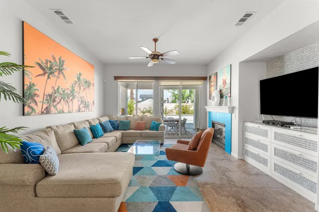 a living room with furniture a chandelier and a large window