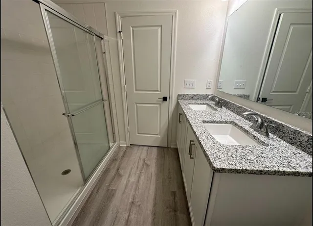 a bathroom with a granite countertop sink toilet and shower