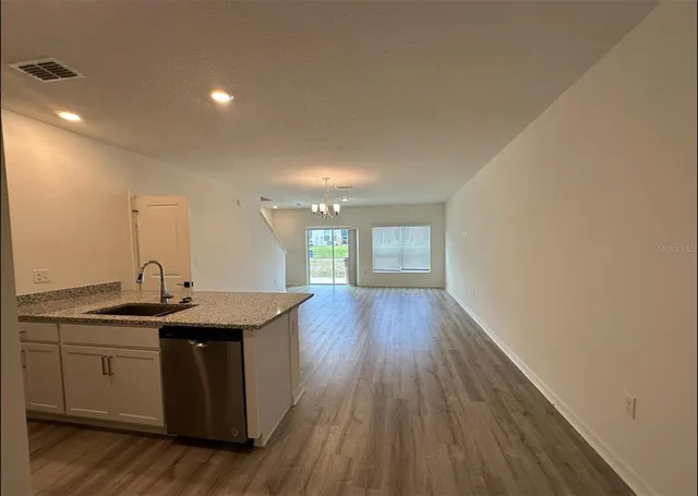 a kitchen with a sink and wooden floor