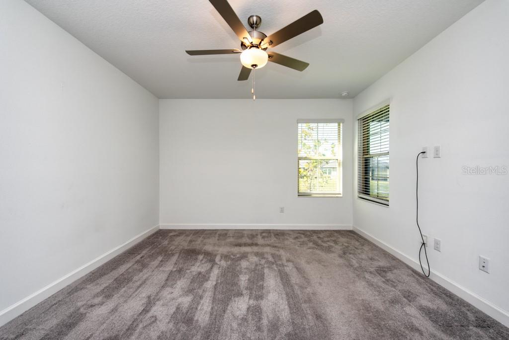 10976 Gable Dig Loop San Antonio, FL 33576 - Photo 13 of 37 wooden floor in an empty room with a window