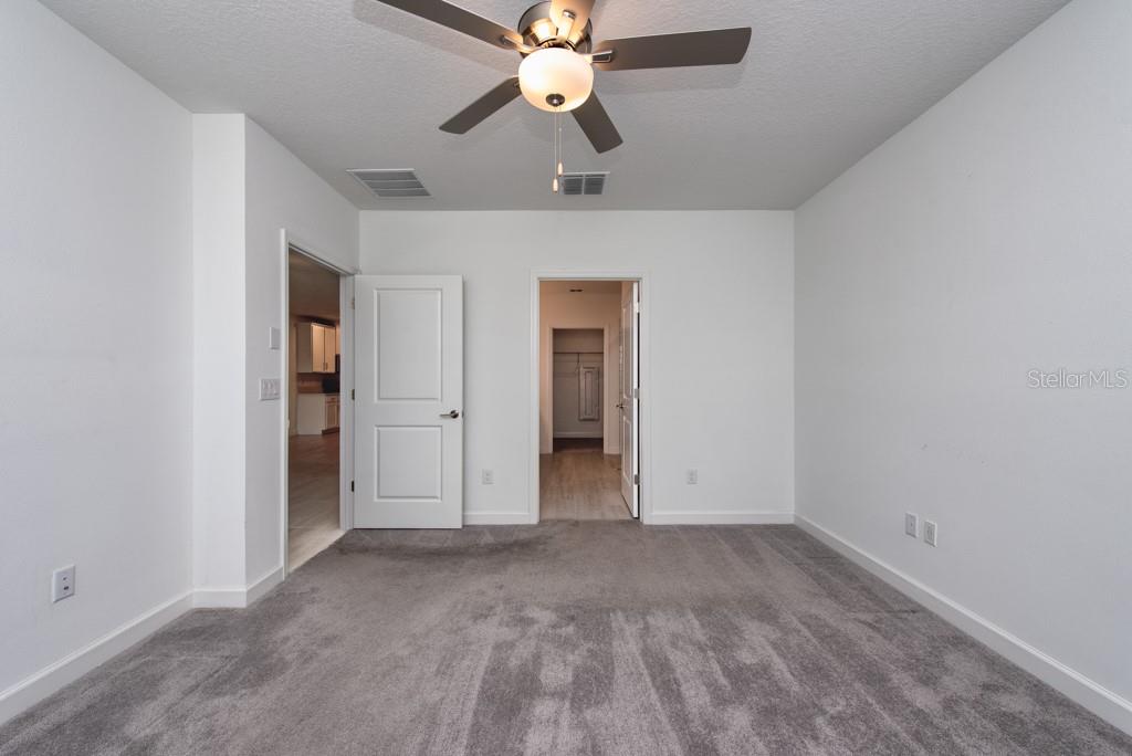 10976 Gable Dig Loop San Antonio, FL 33576 - Photo 15 of 37 an empty room with closet and a chandelier fan