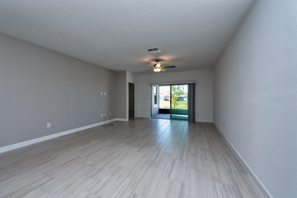 10976 Gable Dig Loop San Antonio, FL 33576 - Photo 7 of 37 a view of an empty room with window and wooden floor