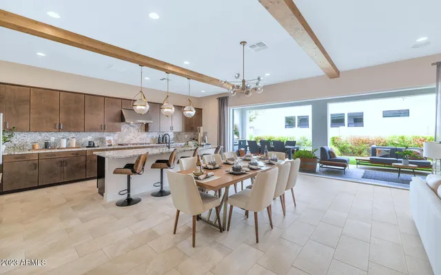 a open kitchen with stainless steel appliances granite countertop a table and chairs in it