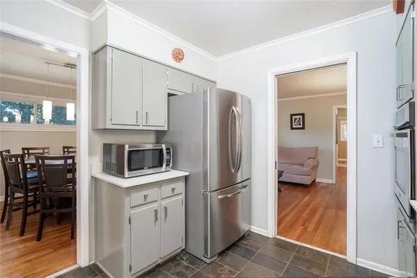 a kitchen with white cabinets and refrigerator