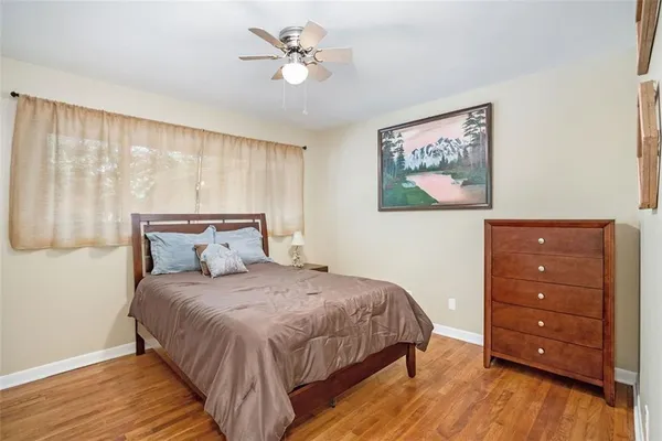 a bedroom with a bed and a painting on the wall