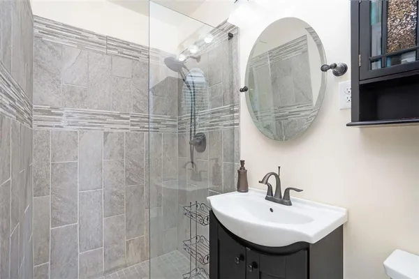 a bathroom with a sink a mirror a vanity and shower