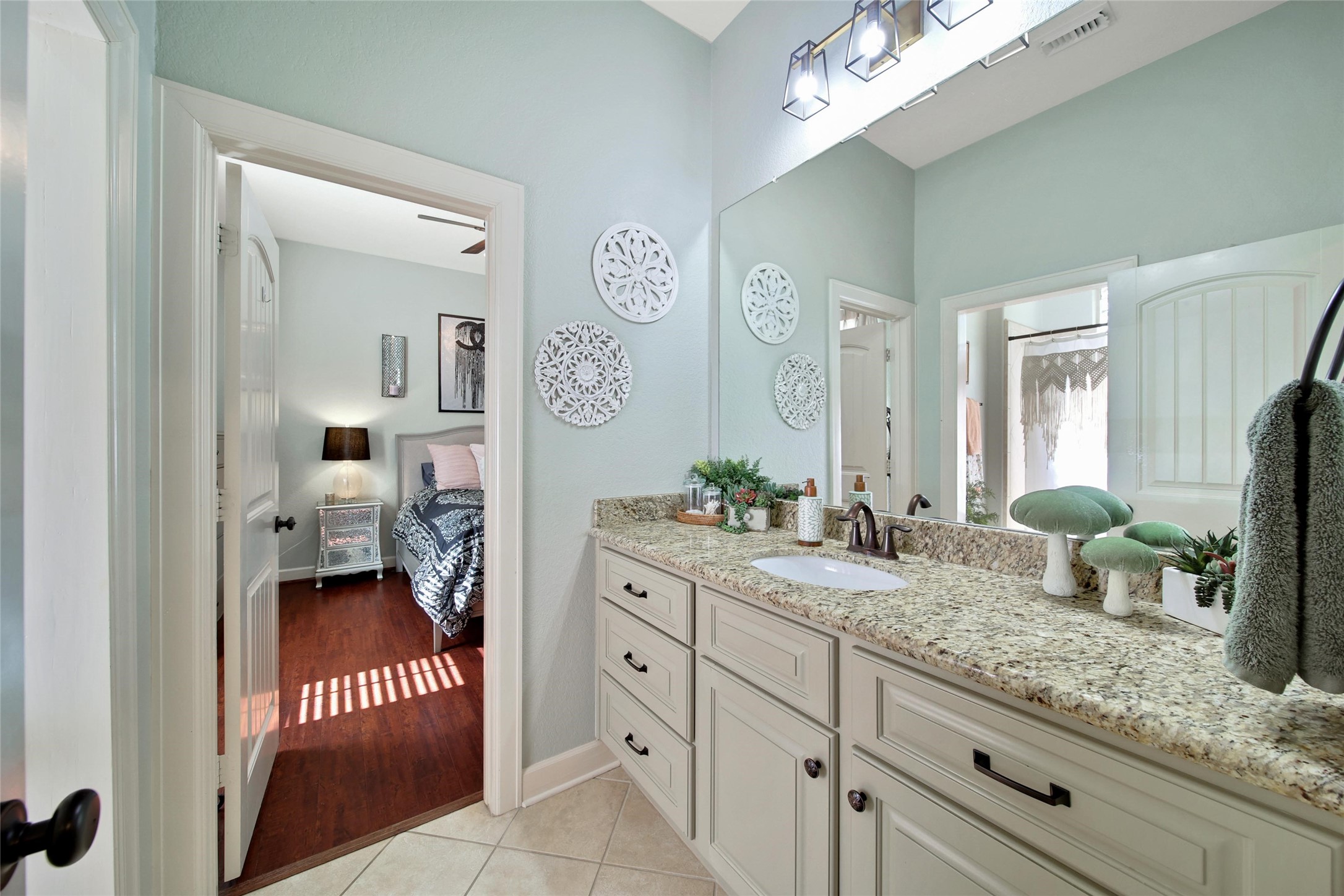 26122 Crown Ranch Boulevard Montgomery, TX 77316 - Photo 21 of 31 a en suite bathroom with a granite countertop sink and a mirror