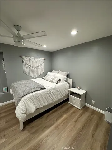 a bedroom with a bed and wooden floor