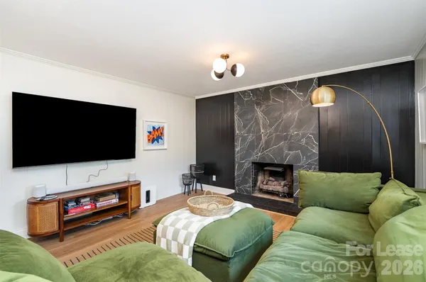 a living room with furniture a flat screen tv and a fireplace