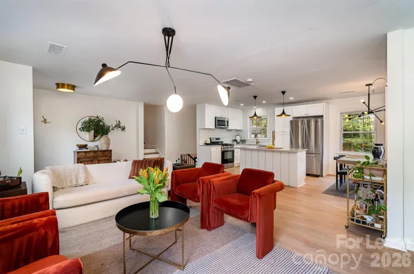 a living room with furniture a chandelier and a dining table