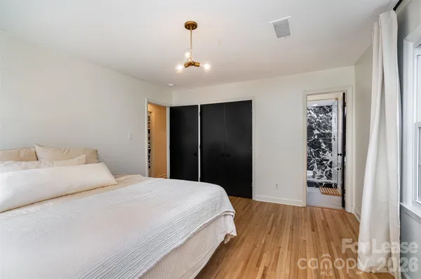 a bedroom with a large bed and a chandelier