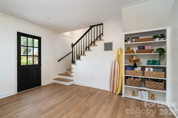 a view of a hallway with wooden floor and entryway