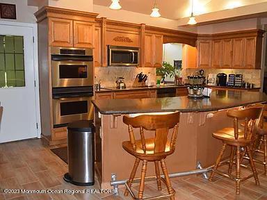 470 Monmouth Place Long Branch, NJ 07740 - Photo 3 of 25 a kitchen with stainless steel appliances granite countertop a stove a sink and a microwave
