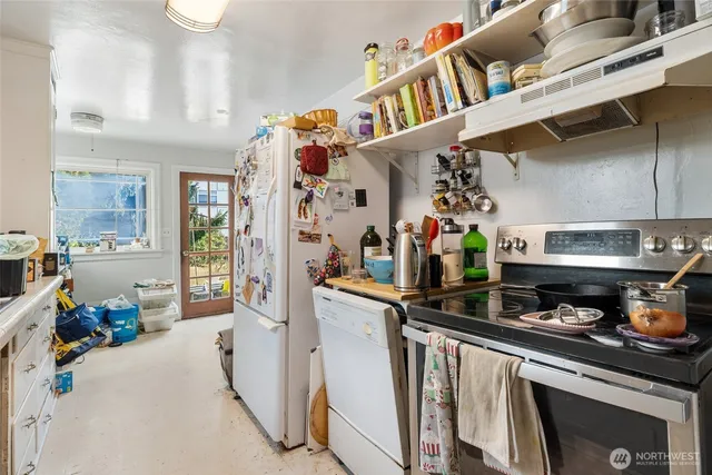 a kitchen with stainless steel appliances granite countertop a lot of cabinets and refrigerator