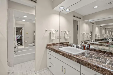 a bathroom with a granite countertop sink and a mirror