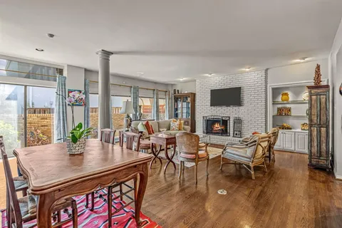 a view of a livingroom with furniture a fireplace and wooden floor