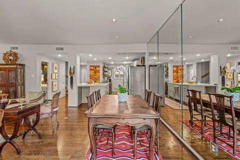 a kitchen with stainless steel appliances kitchen island granite countertop a table chairs and a refrigerator