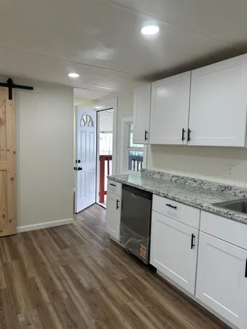 an empty room with wooden floor and door