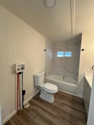 a bathroom with a tub sink toilet and mirror