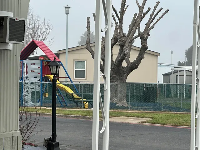 a view of kitchen and empty room with wooden floor