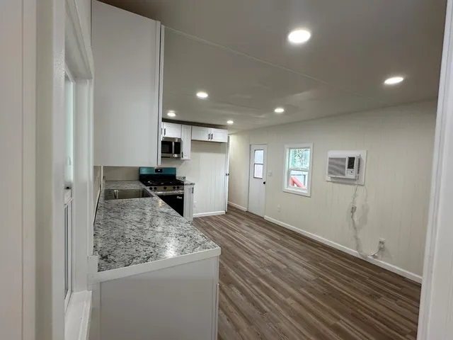 a kitchen with stainless steel appliances granite countertop a sink stove and cabinets