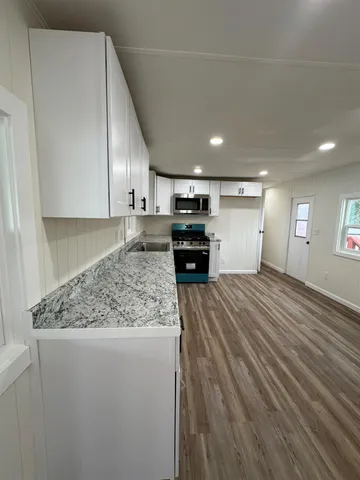 a large kitchen with stainless steel appliances granite countertop a stove and a refrigerator