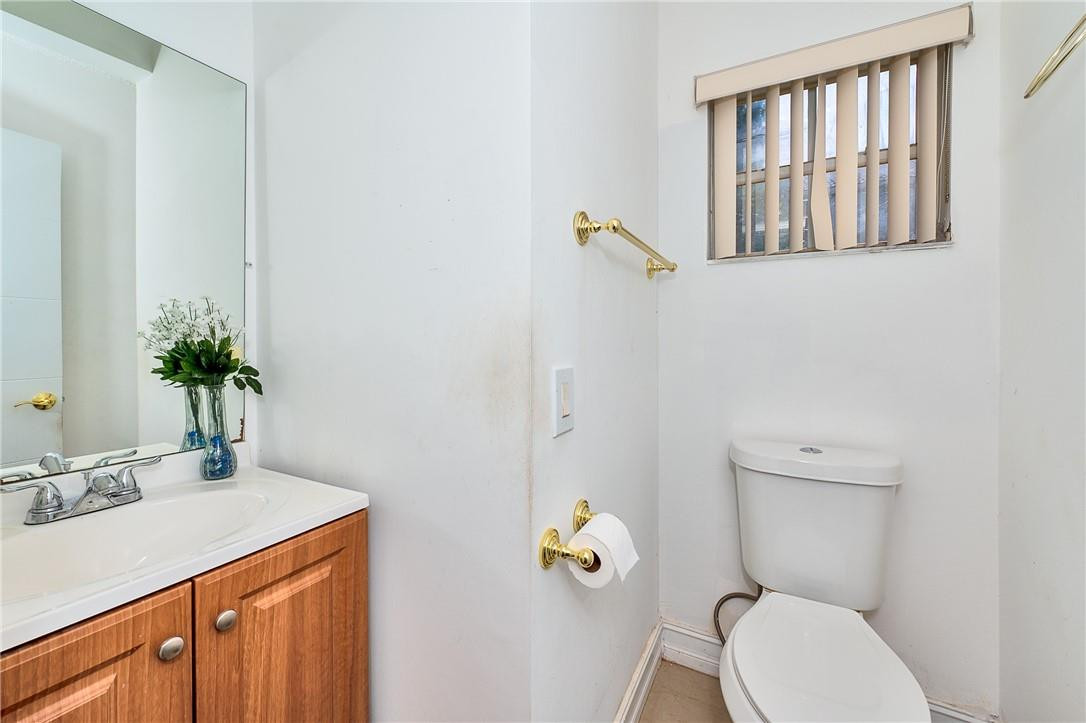 833 Falling Water Road Weston, FL 33326 - Photo 13 of 32 a bathroom with a granite countertop toilet sink and mirror