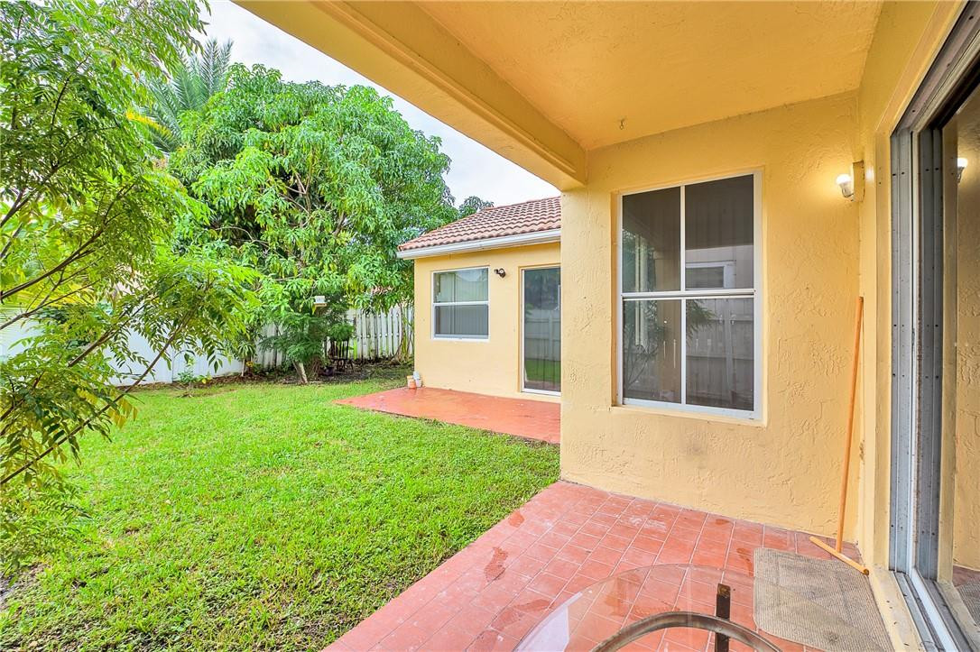833 Falling Water Road Weston, FL 33326 - Photo 20 of 32 a view of a backyard with potted plants and floor to ceiling window