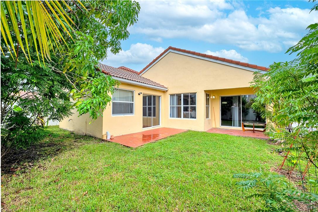 833 Falling Water Road Weston, FL 33326 - Photo 23 of 32 a front view of house with yard and green space