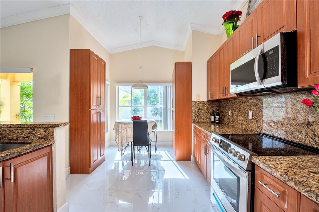 833 Falling Water Road Weston, FL 33326 - Photo 8 of 32 a kitchen with stainless steel appliances granite countertop a stove a sink and a microwave