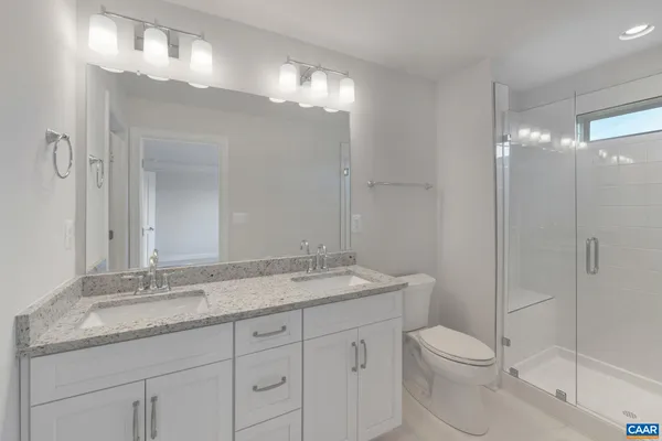 a bathroom with a granite countertop sink a toilet and a mirror