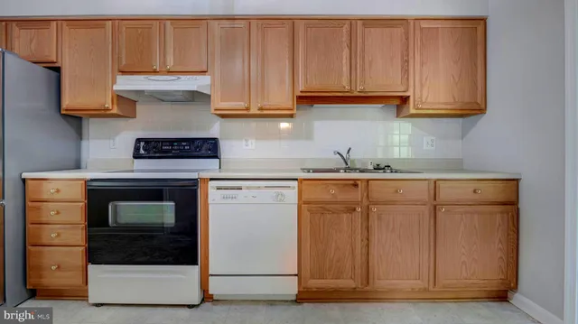 a kitchen with granite countertop a stove and a white cabinet