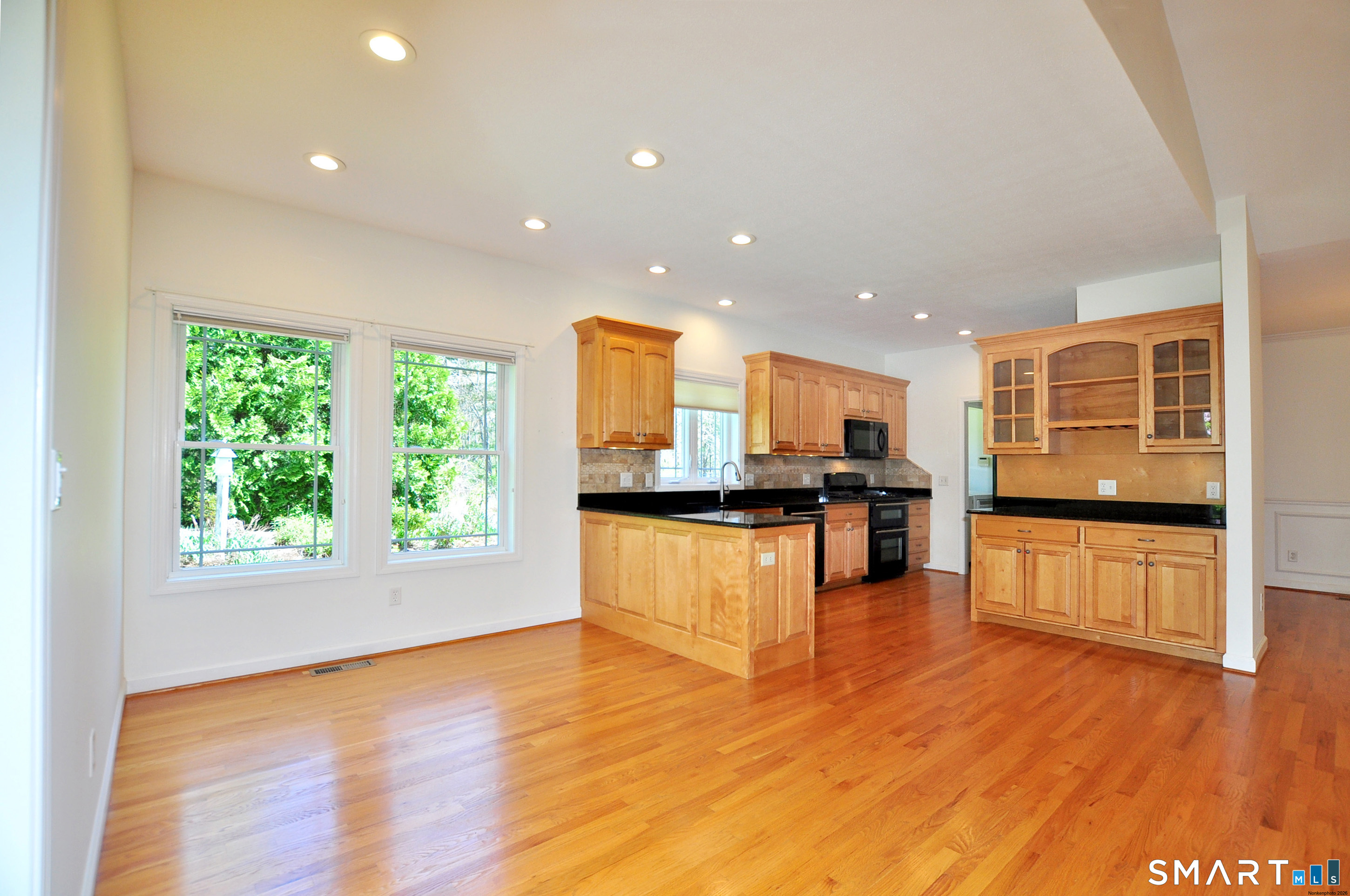 453 Tributary Lane Windsor, CT 06095 - Photo 11 of 37 a view of kitchen with stainless steel appliances granite countertop a stove top oven a sink with wooden floors and large trees