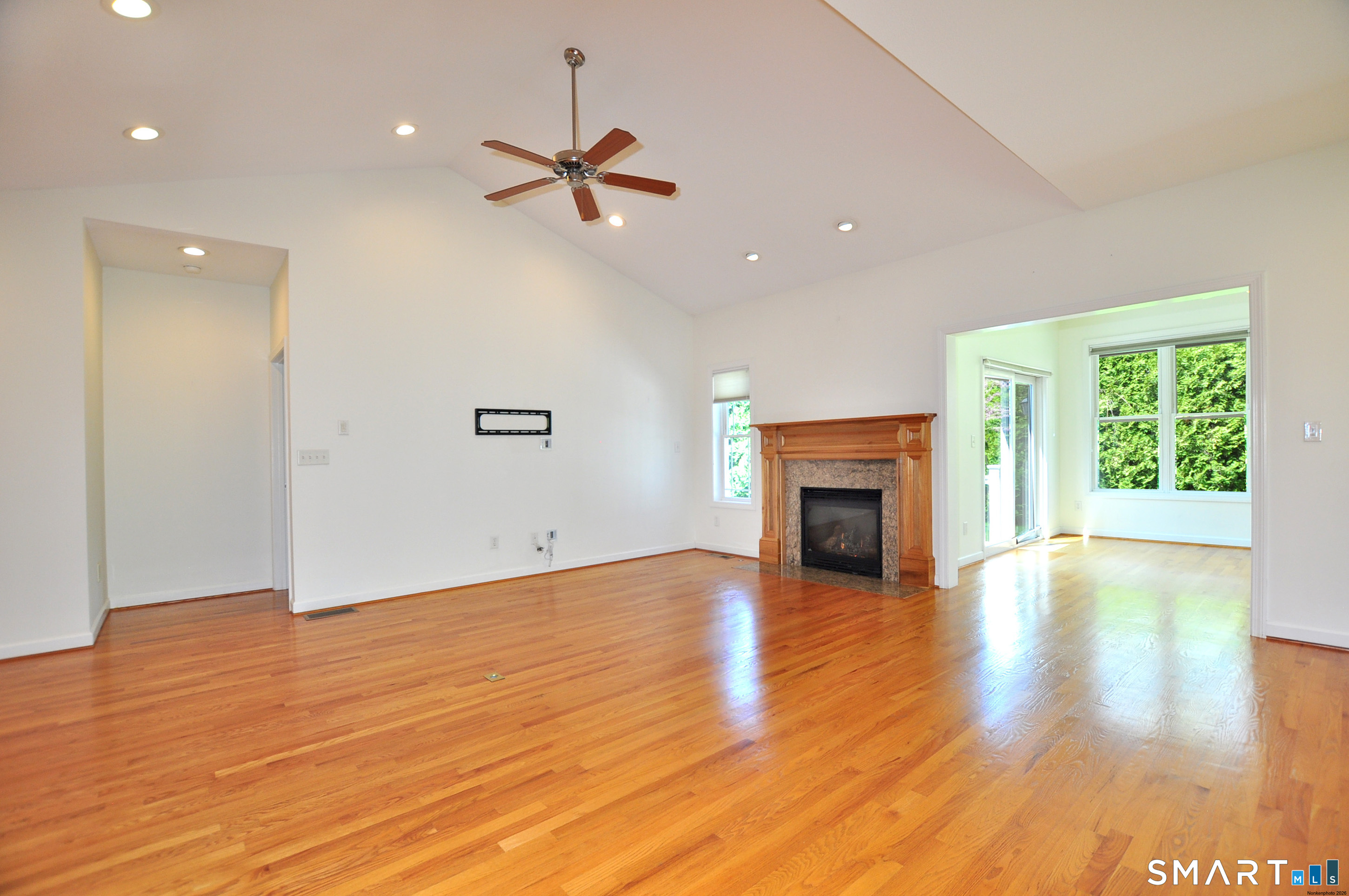 453 Tributary Lane Windsor, CT 06095 - Photo 9 of 37 an empty room with wooden floor fireplace and windows