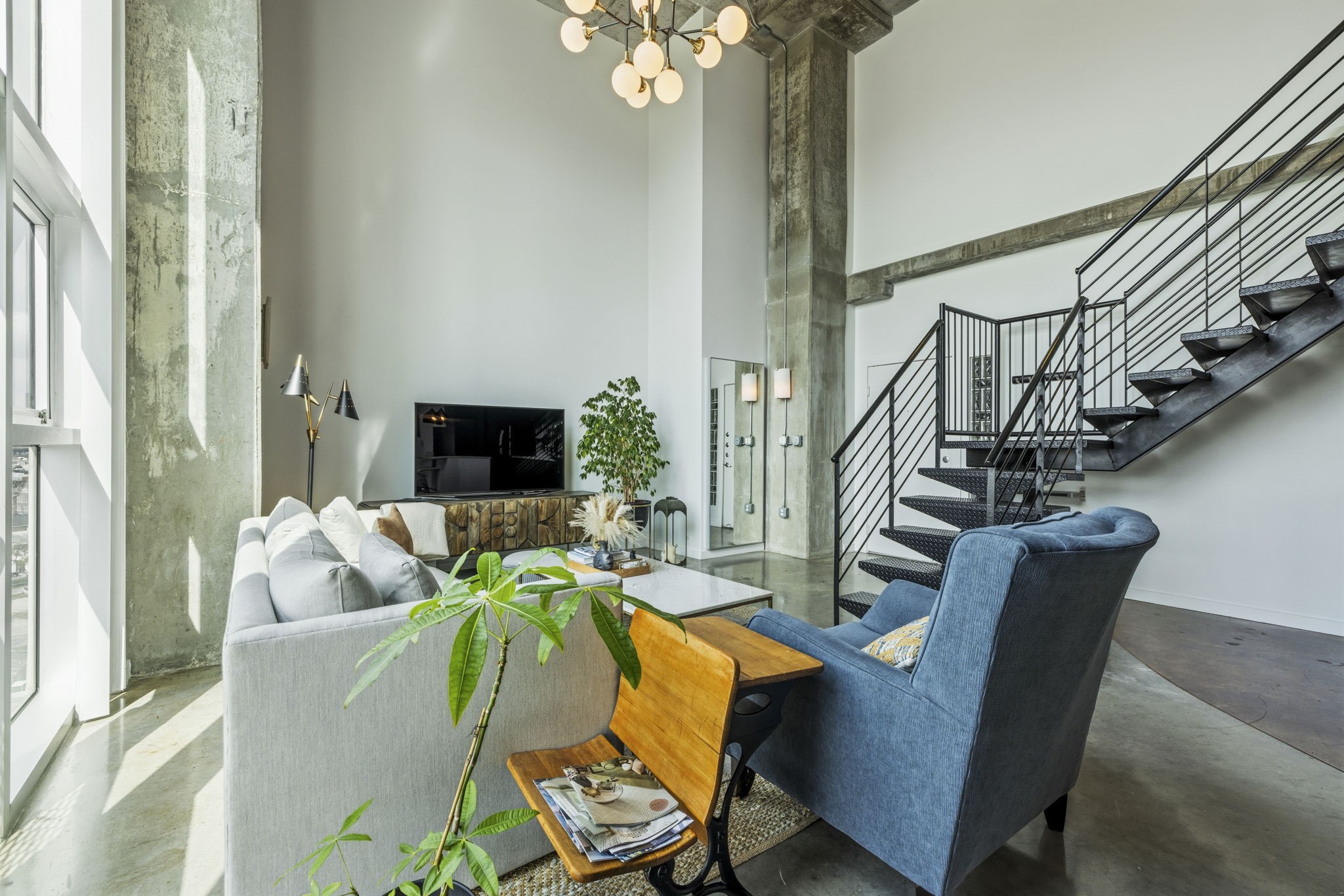 2000 Bagby Street, Unit 11415 Houston, TX 77002 - Photo 5 of 35 Inviting living area has high ceilings, abundance of natural light and a striking chandelier centerpiece. Additional built in storage (not pictured) is located behind column.