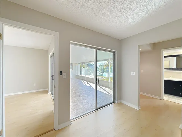 an empty room with sliding door and wooden floor