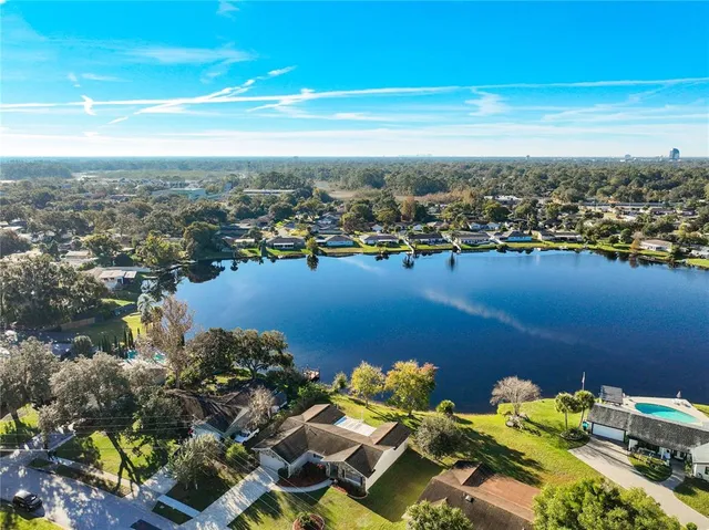 an aerial view of ocean and residential houses with outdoor space