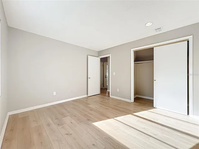 a view of an empty room with wooden floor