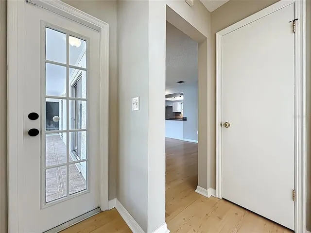 a view of an empty room with window and wooden floor