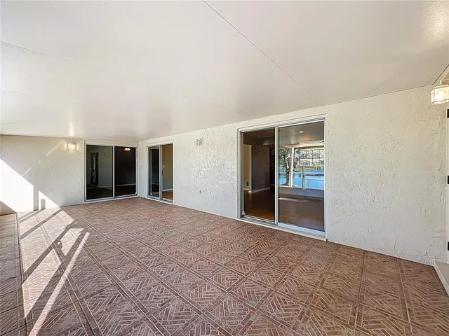 a view of an empty room with closet and a bathroom