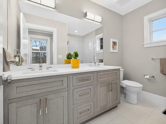 a bathroom with a double vanity sink and a toilet
