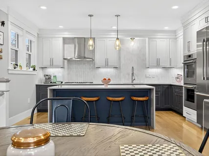 a kitchen with kitchen island stainless steel appliances a sink a stove and a wooden floors