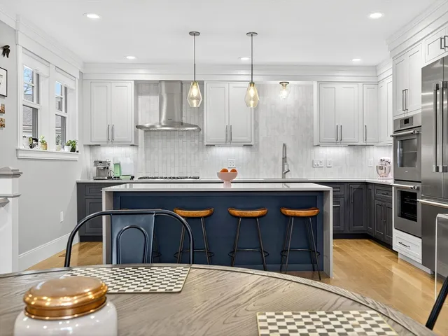 a kitchen with stainless steel appliances granite countertop a stove a sink and a refrigerator