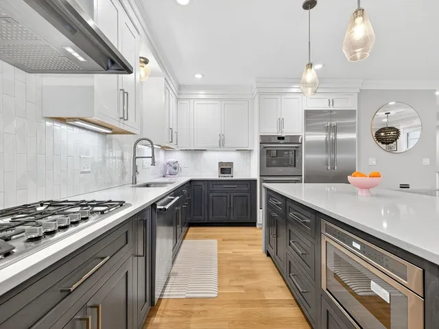 a kitchen with kitchen island stainless steel appliances a sink a stove and a wooden floors