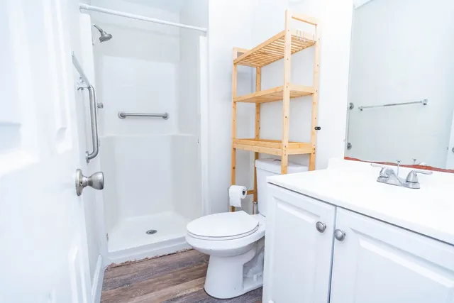 a bathroom with a sink a toilet and shower