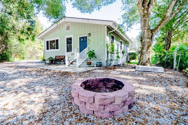 a view of a house with backyard and sitting area