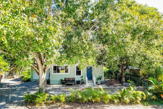 a view of a backyard with table and chairs and potted plants