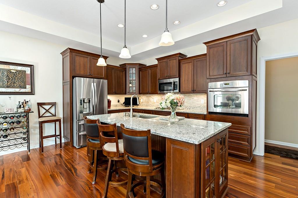 137 Cobblestone Drive Pittsburgh, PA 15237 - Photo 11 of 39 a kitchen with stainless steel appliances granite countertop a kitchen island a stove a refrigerator a sink a dining table and chairs with wooden floor